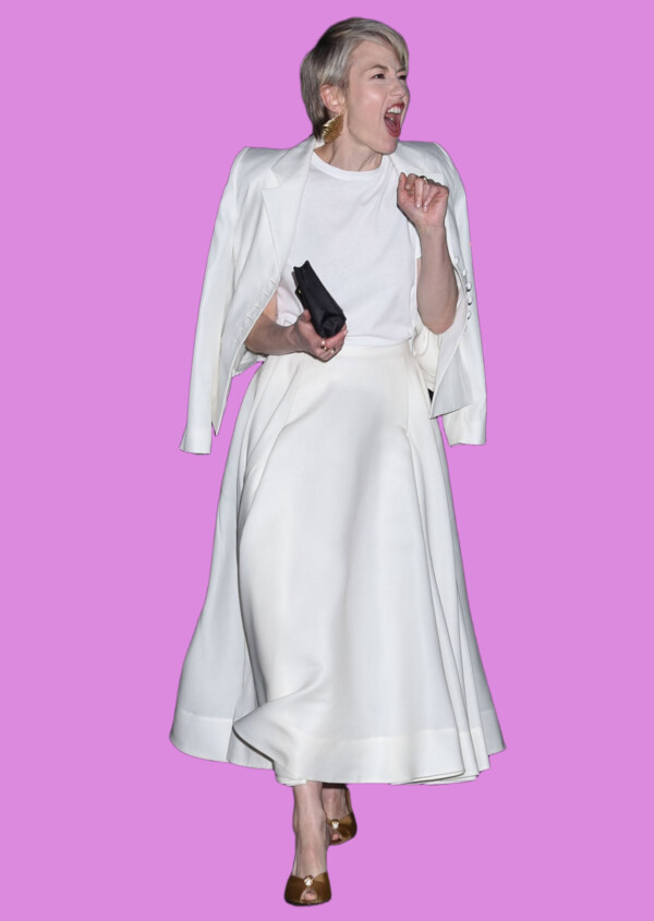 A woman in a white dress and blazer celebrating on a city street, bla bla.