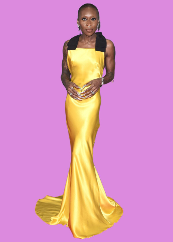 A woman in a stunning yellow satin gown with black shoulder accents, standing on a red carpet at the BFI London Film Festival, bla bla.