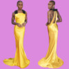 A woman in a yellow satin gown with black shoulder accents, standing on a red carpet at a film festival, bla bla.