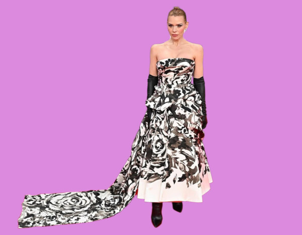 Fashion model wearing a strapless floral gown with long black gloves, standing against a purple background. bla bla.