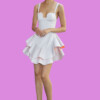 Fashionable woman in a white dress with ruffled skirt and orange heels, bla bla.
