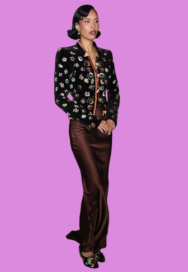 Fashionable woman in a black embroidered jacket and satin brown pants, bla bla.