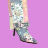 A stylish floral boot with a pointed toe and a small heel, part of a colorful patchwork outfit, bla bla.