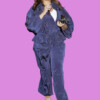 A fashionable woman in a blue tracksuit walking in an urban setting at night, bla bla.