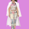 A woman with curly hair and sunglasses wearing a patchwork outfit and white coat, smiling against a purple background. bla bla.
