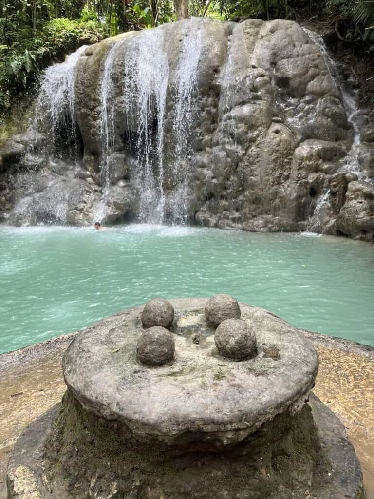 Flowing waterfall over rocks in lush jungle setting at AdrianStage.