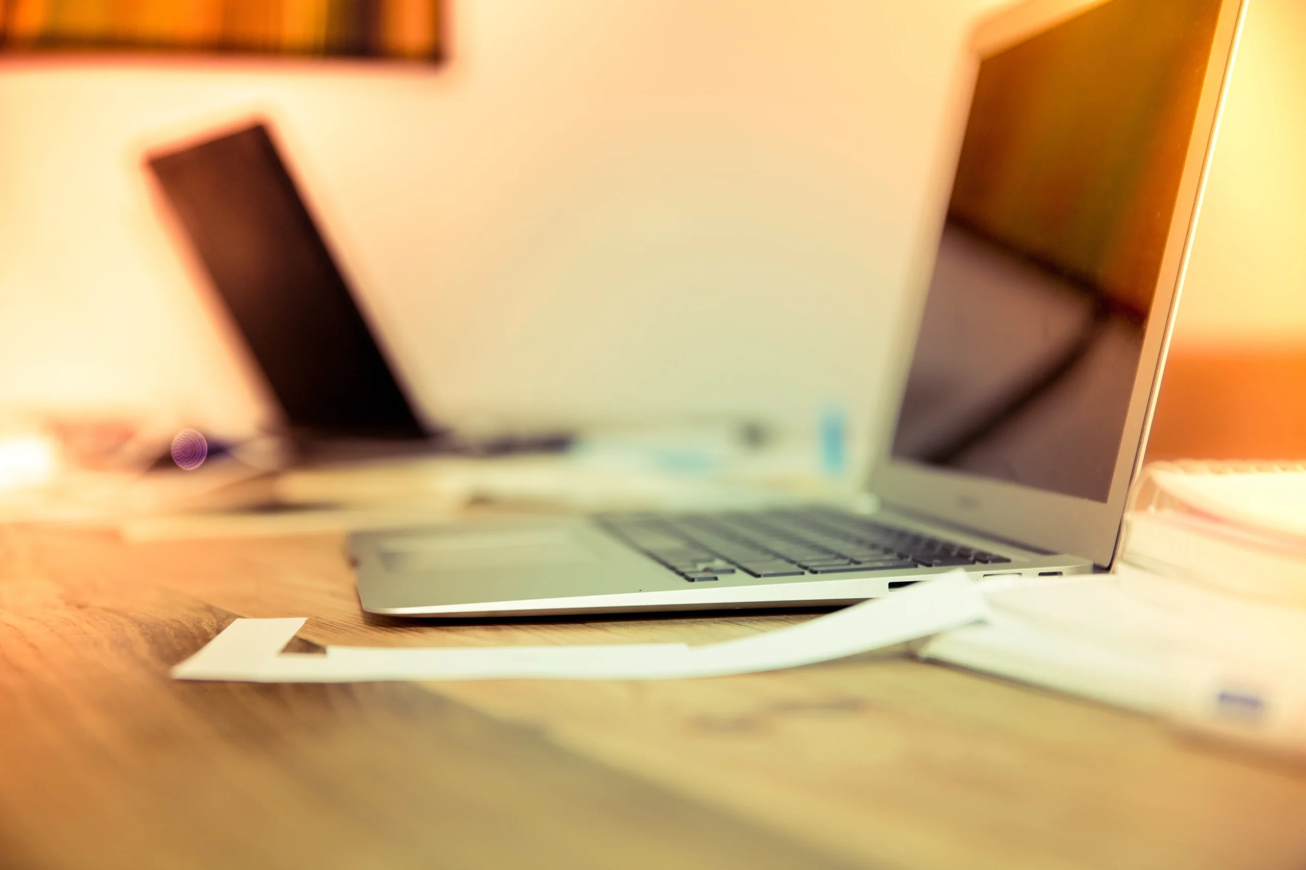 Laptop on a wooden desk with a blurred background, showcasing modern technology and workspace ambiance for AdrianStage website.